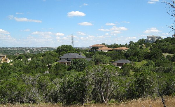 Stone and stucco Hill Country homes among cedar and live oak on a limestone ridge west of Austin, the terrain Bee Cave 78738 is built on