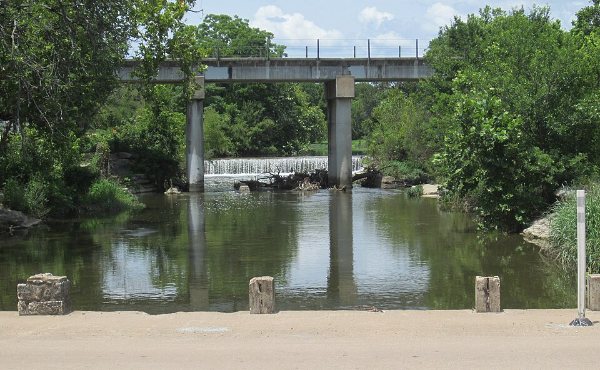 Brushy Creek running under a low bridge in Round Rock, TX, the limestone crossing the city is named for, in 78664