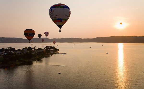Hot air balloons over Lake Travis at sunrise, the upper-lake setting the Spicewood 78669 market sits on