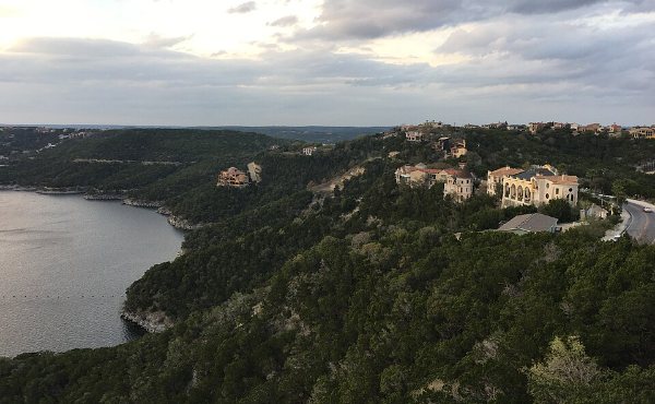 Cedar and live oak hillsides dropping steeply to the water west of Austin, the terraced terrain Westlake Hills 78746 homes are built into
